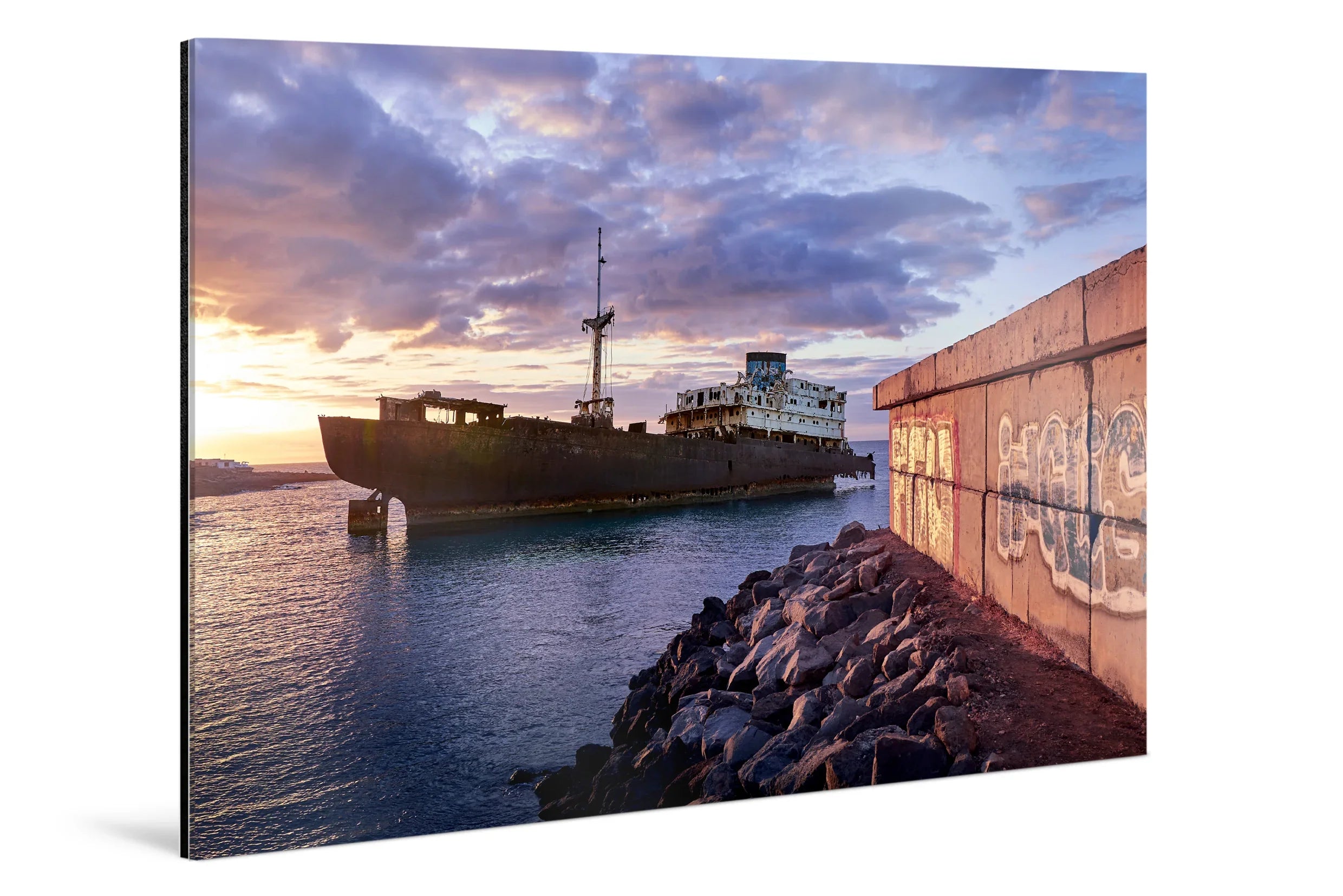 Rusting ghost ship floating near rocky shore under dramatic blue and purple sunset clouds. - 45 x 30cm / Photo hinter Acrylglas / Unframed