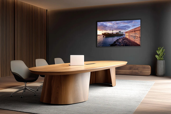 Modern conference room with wooden oval table, gray swivel chairs, and wall art of a ship at blue hour by the sea. - 45 x 30cm / Photo hinter Acrylglas / Unframed