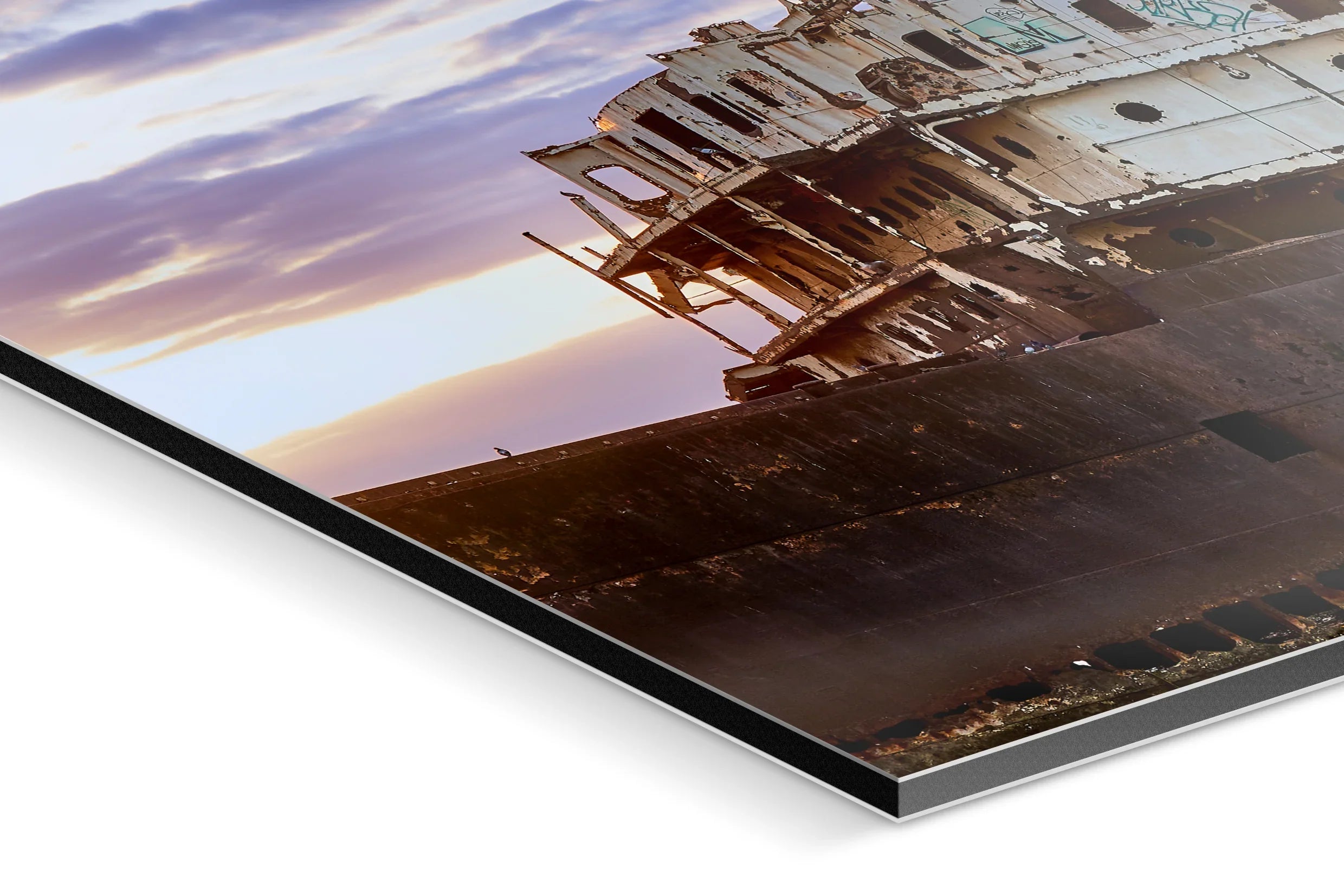 Close-up of a weathered rusted ship hull with peeling white paint against a cloudy sky at sunset. - 45 x 30cm / Photo hinter Acrylglas / Unframed