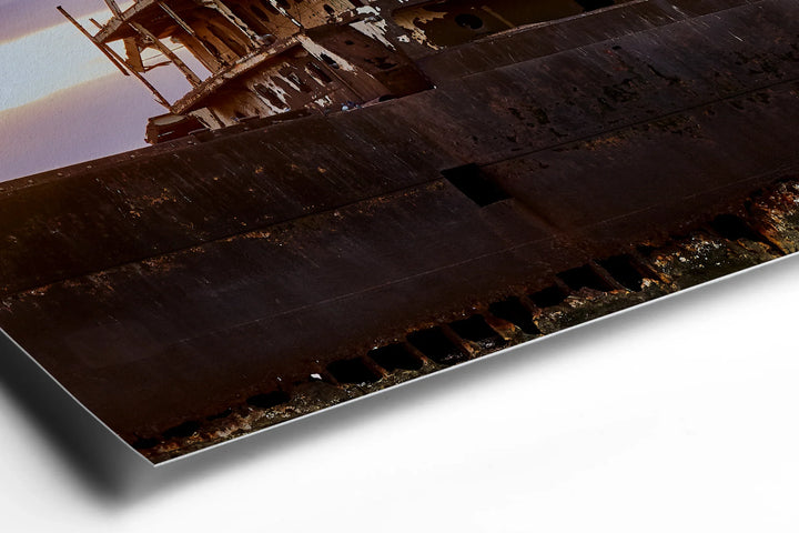 Rusty hull of a large abandoned ship with weathered metal plates and jagged edges against a dark background. - 45 x 30cm / Photo hinter Acrylglas / Unframed